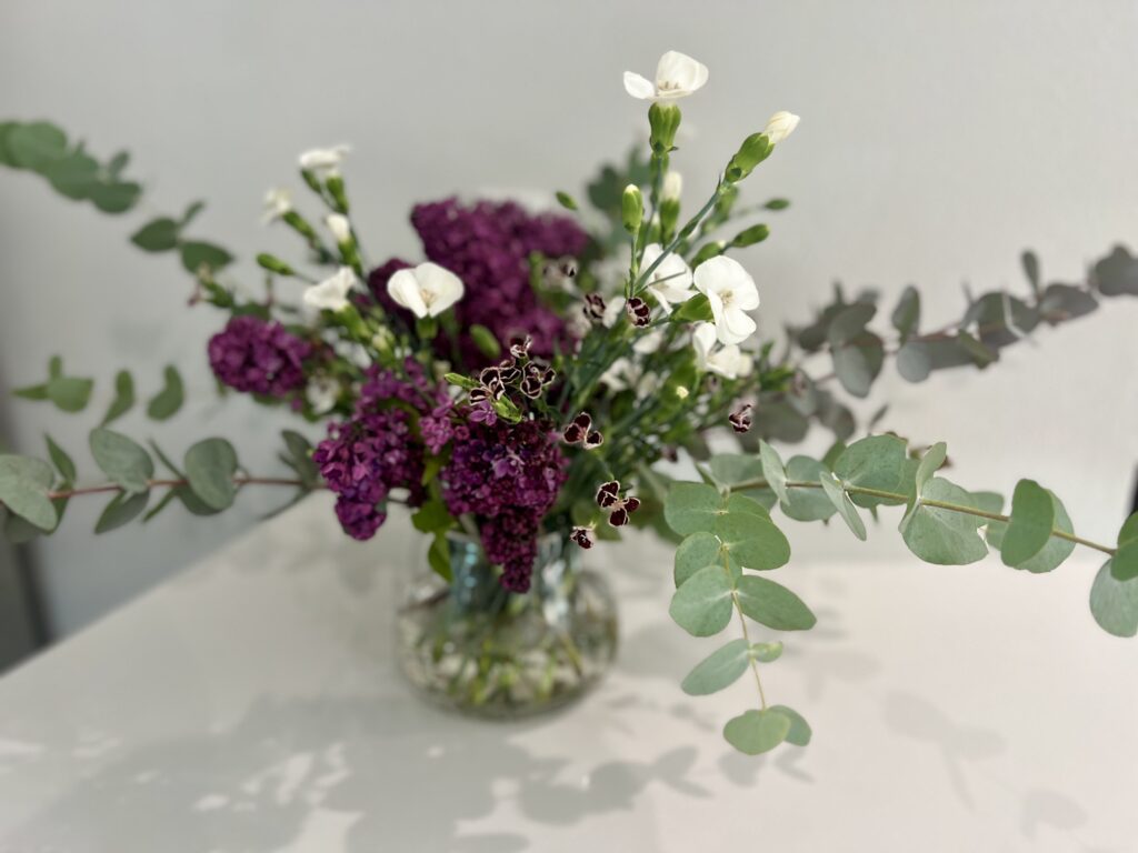 The final result: French lilac, eucalyptus, and dianthus arranged in a glass vase